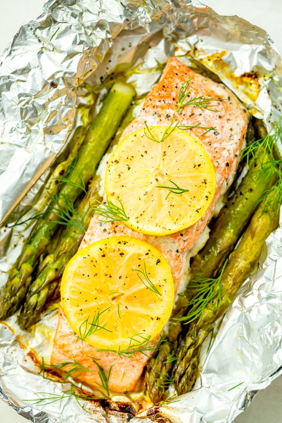 paquet de feuille de saumon grillé avec asperges, citron et aneth