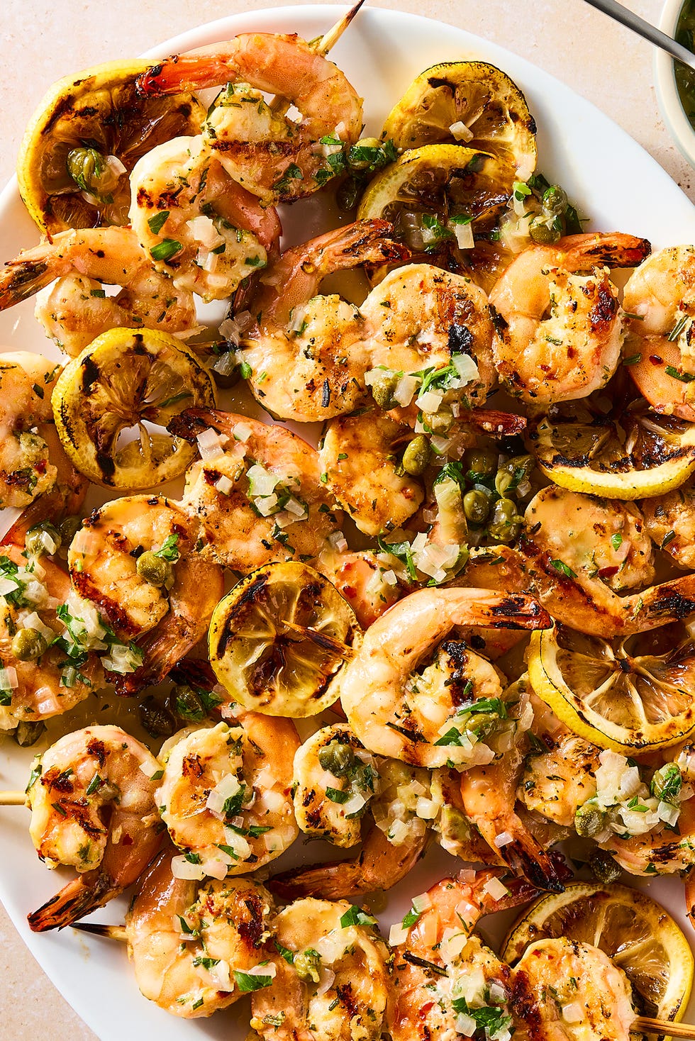 Crevettes juteuses et carbonisées, zeste de citron brillant, câpres saumâtres et sauce au beurre au vin blanc