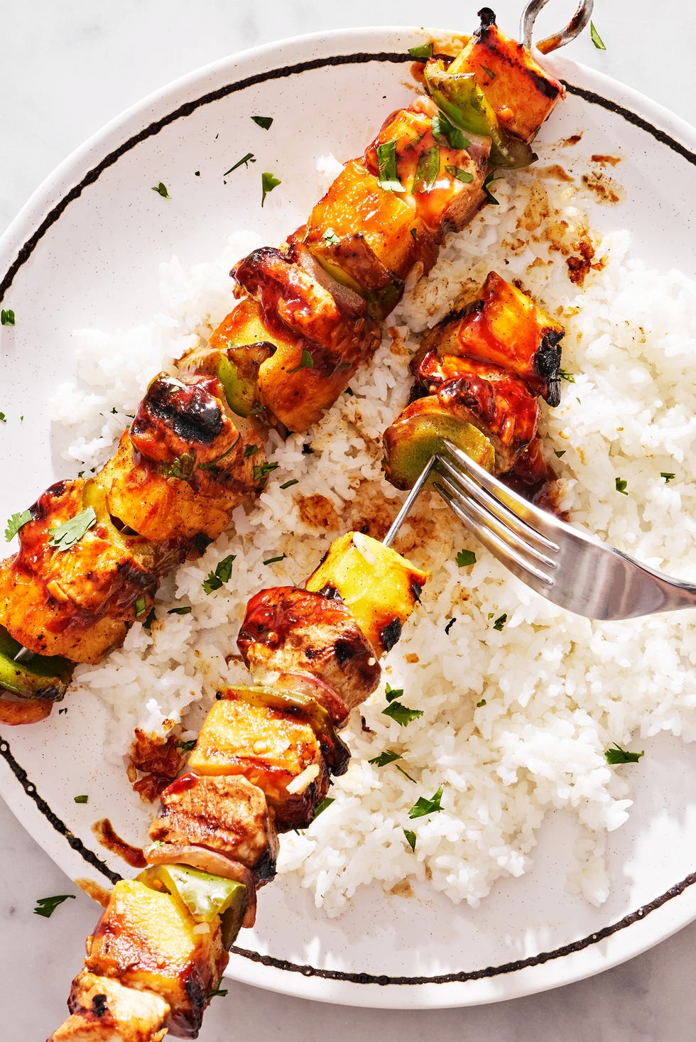 poulet, ananas et poivrons sur une brochette arrosée de teriyaki