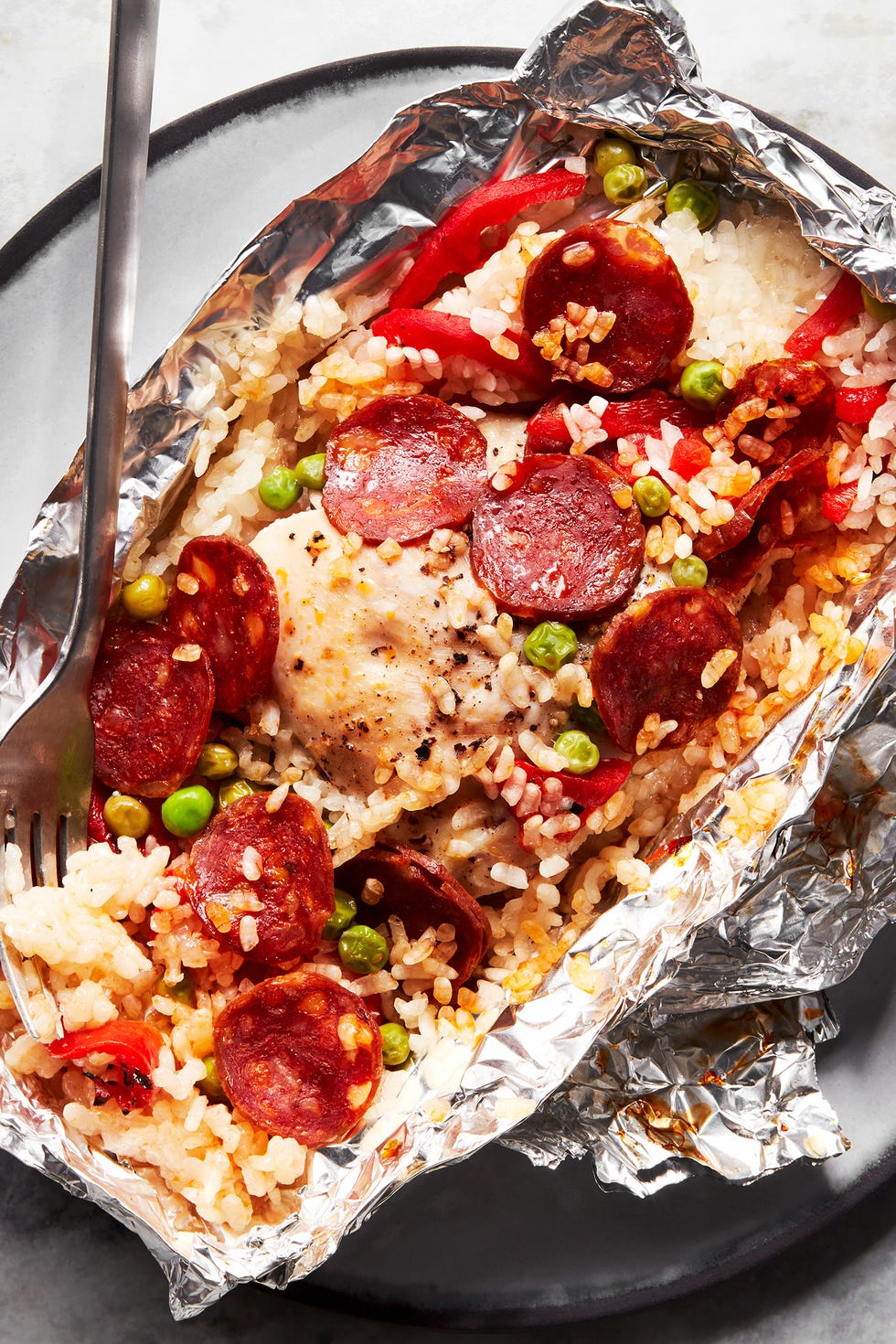 paquets de papier d'aluminium remplis de riz, de pois, de pepperonis et de poivrons