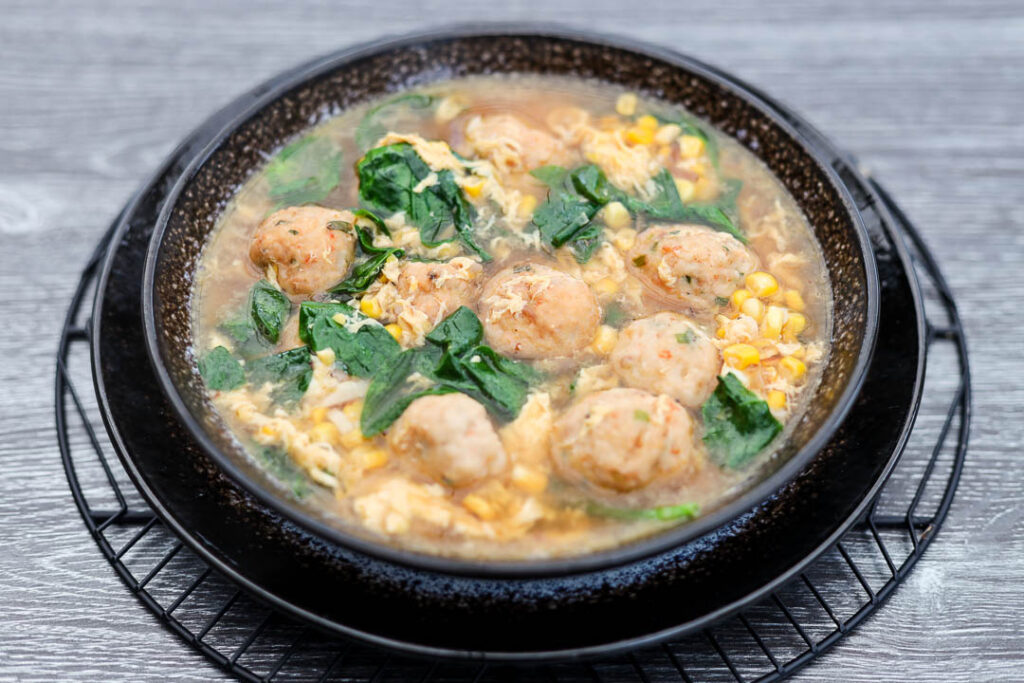 Soupe de maïs et d'épinards aux boulettes de crevettes et de crabe