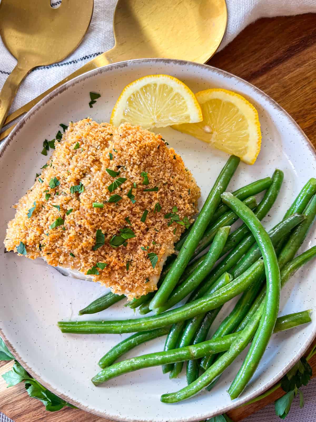 Morue charbonnière sur une assiette blanche avec des haricots verts.