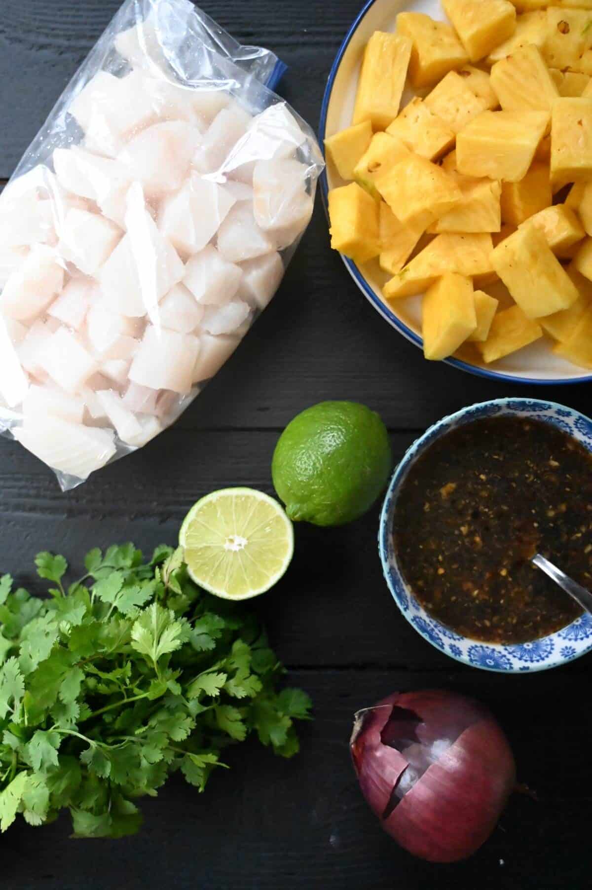 ingrédients pour brochettes de flétan grillé avec flétan ananas coriandre citron vert oignon rouge et une marinade tropicale aigre-douce