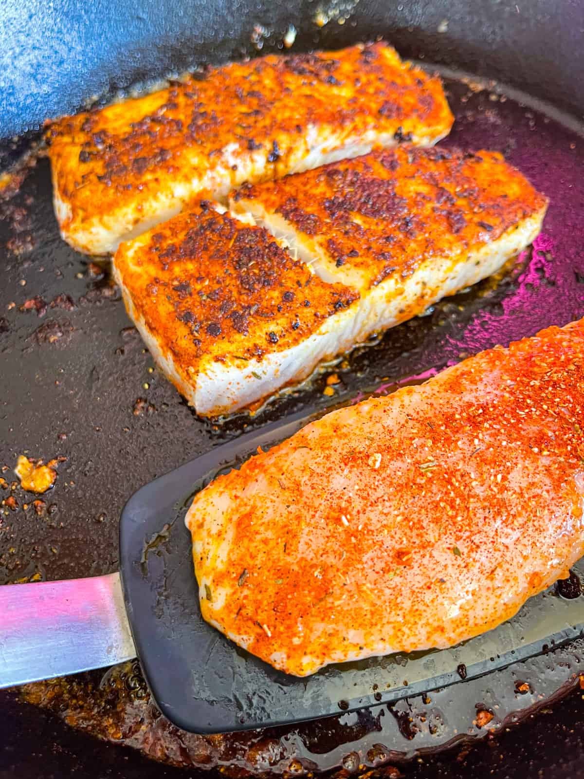 Cuisson du poisson assaisonné dans une poêle.