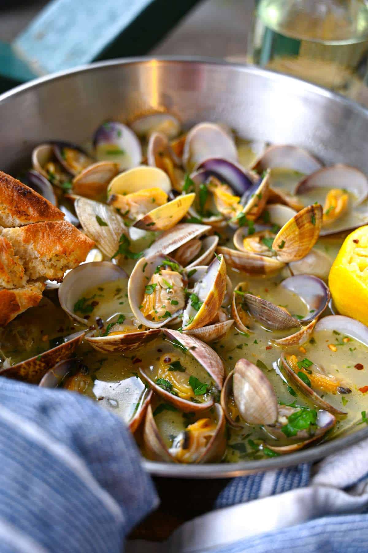 palourdes dans une poêle avec du pain croustillant et du citron et du vin blanc avec du persil