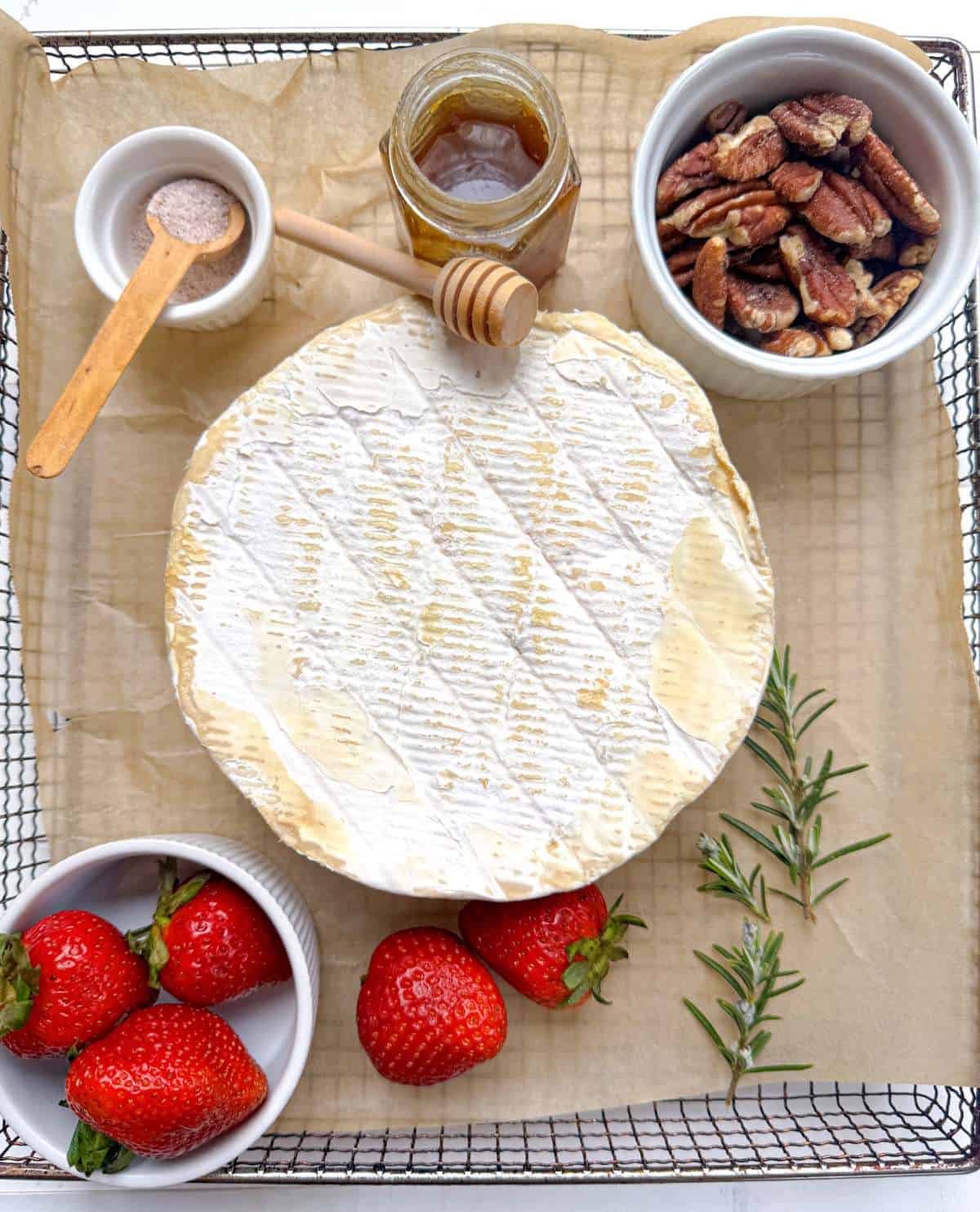 ingrédients pour le brie cuit à la friteuse, le brie double crème, les fraises, le romarin, les pacanes et le miel