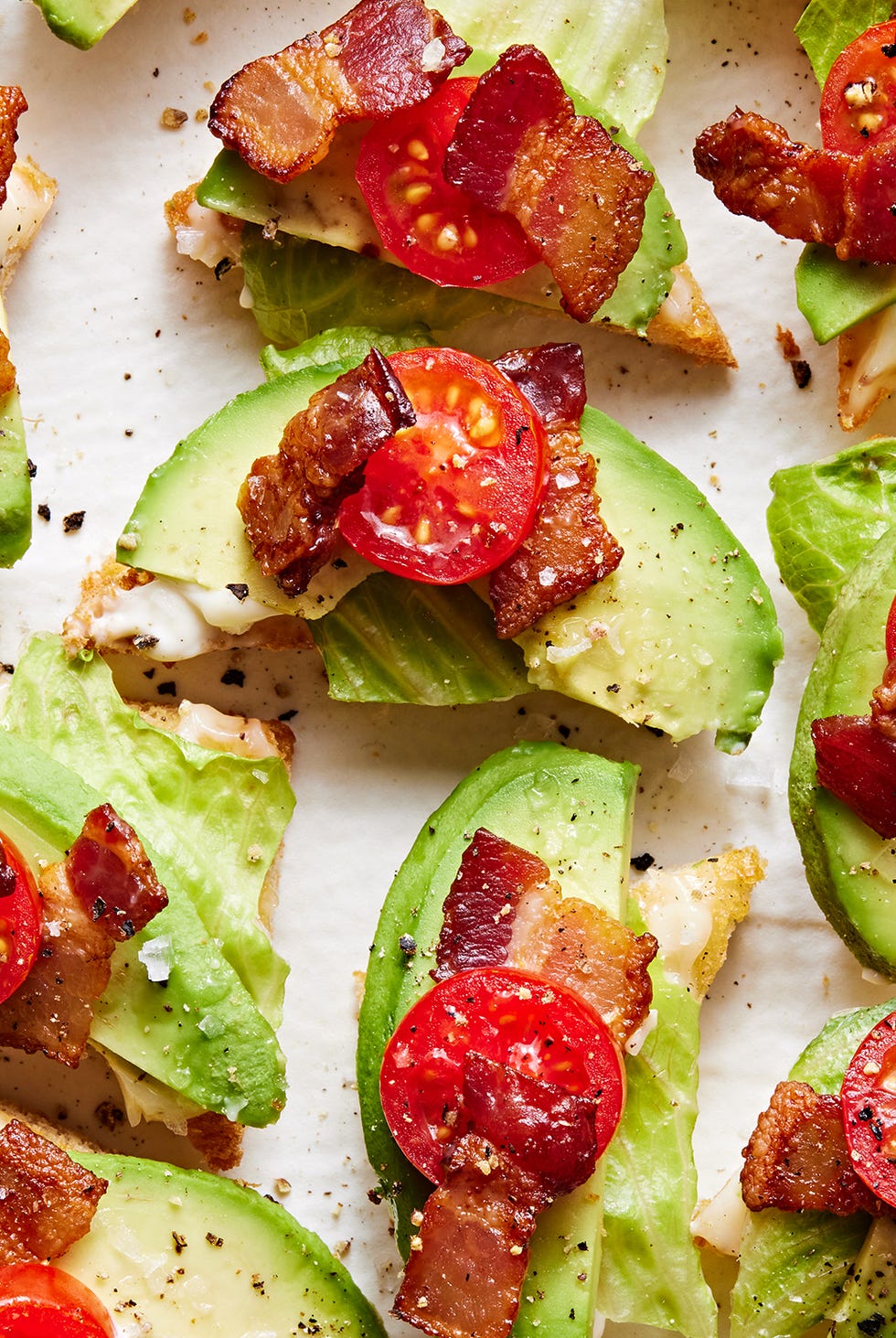 points de pain grillé blancs garnis de laitue, d'avocat, de laitue et de tomate