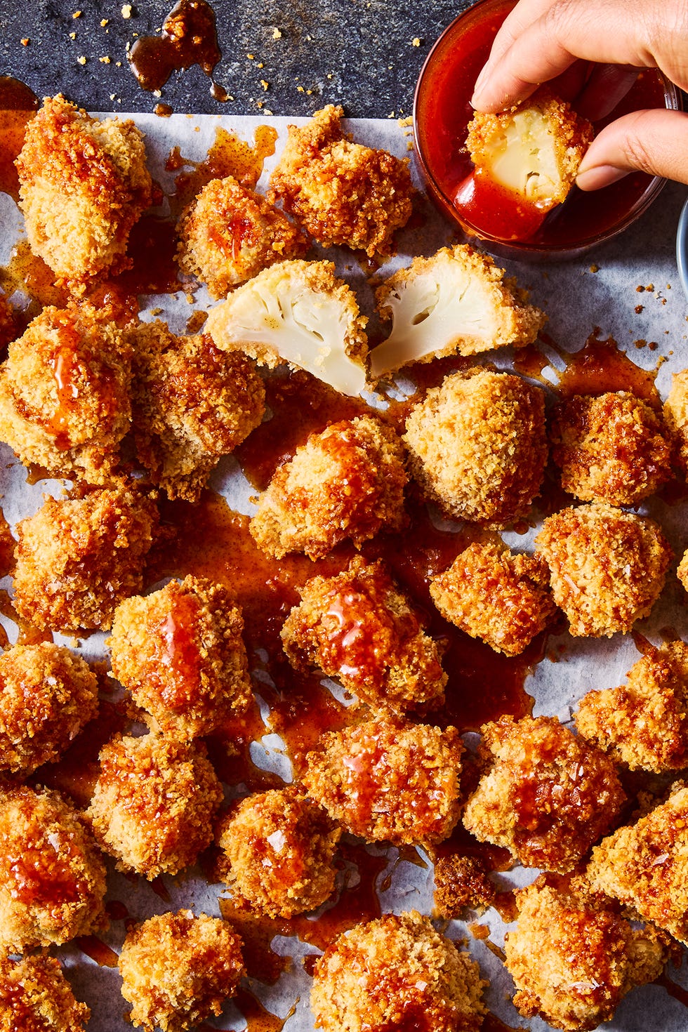 Nuggets de chou-fleur croustillants au miel chaud arrosés de sauce au miel chaud sur papier parchemin