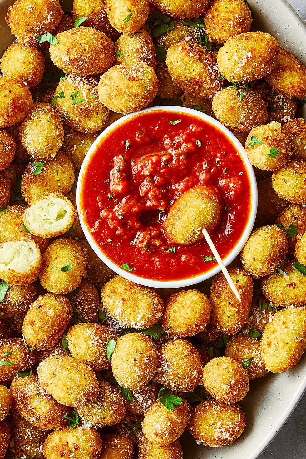 bouchées de gnocchis frits dans un bol avec sauce marinara en accompagnement