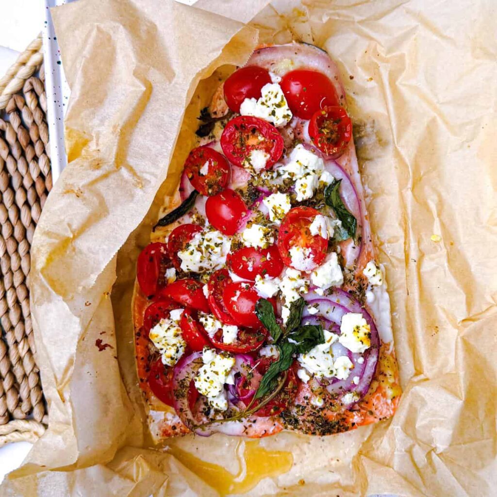 poisson en papillote fish wrapped in parchment paper with feta, tomatoes, red onion and herbs