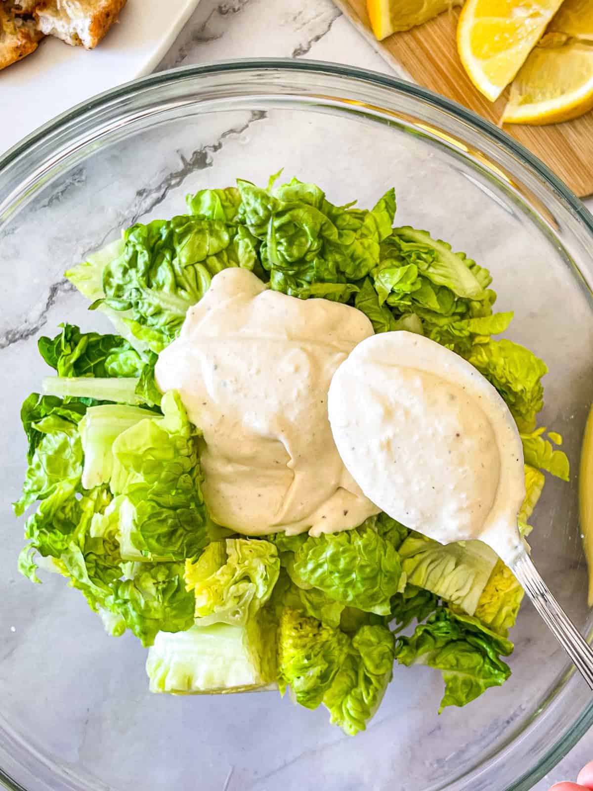 Vinaigrette mélangée à de la laitue romaine dans un bol.