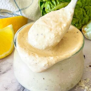 Caesar salad in little jar with a spoon.