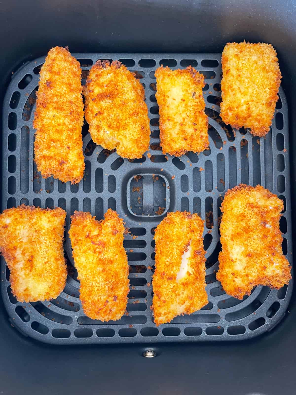 Bâtonnets de poisson retournés dans une friteuse à air.