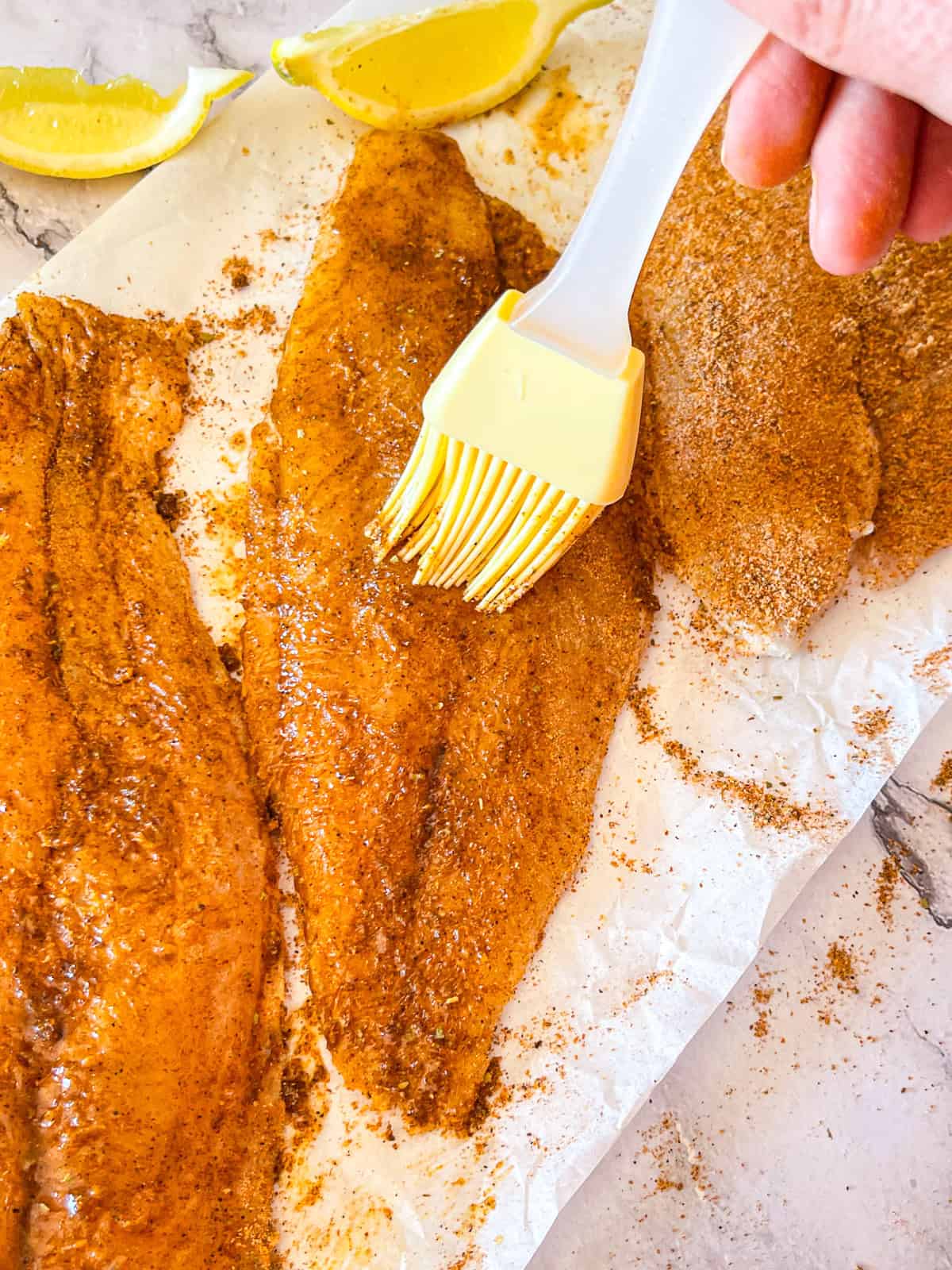 Le poisson-chat assaisonné est brossé de beurre.