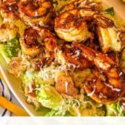 crevettes noircies avec salade César sur un plateau