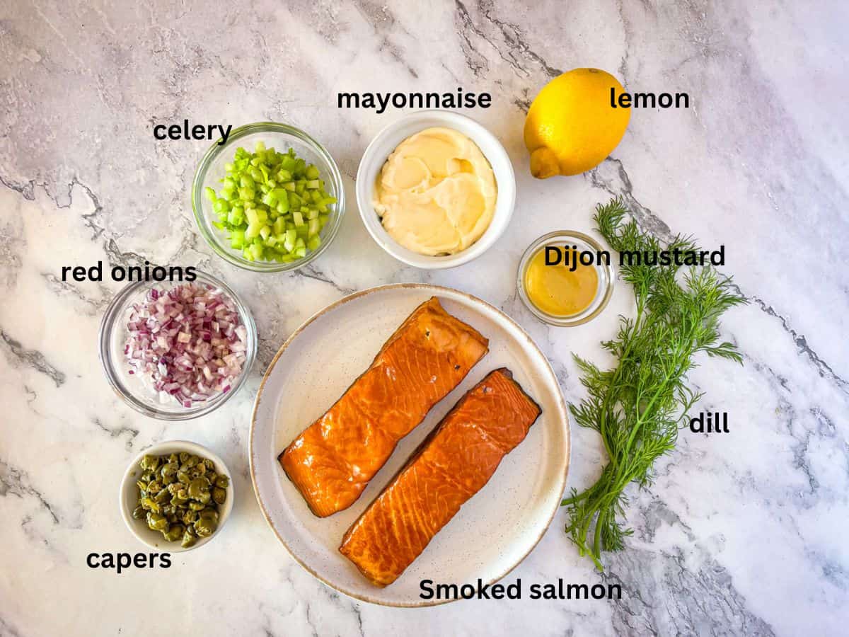Les ingrédients pour la salade de saumon fumée disposés sur une table et étiquetés.