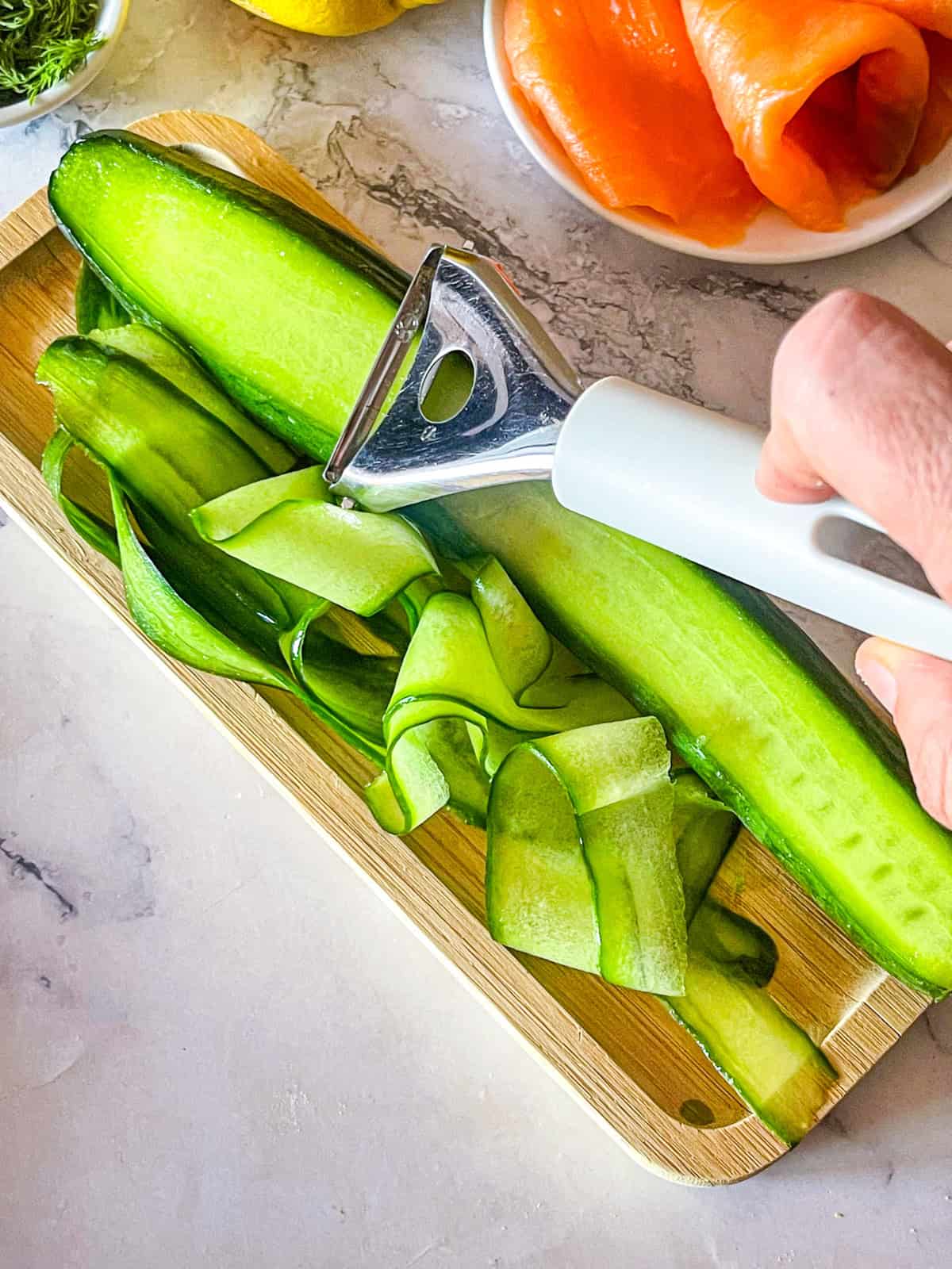 Le concombre décollé dans des rubans sur une planche.