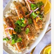 4 morceaux de saumon sur un lit de riz sur une assiette blanche.