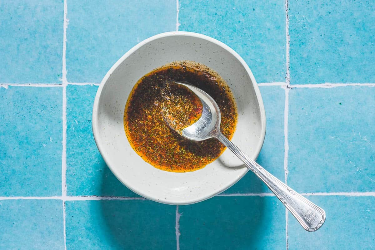 Marinade pour les crevettes aux frites à air dans un bol avec une cuillère.