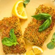 Deux filets mahi mahi mahi brun doré garni de quartiers de citron et de basilic frais.