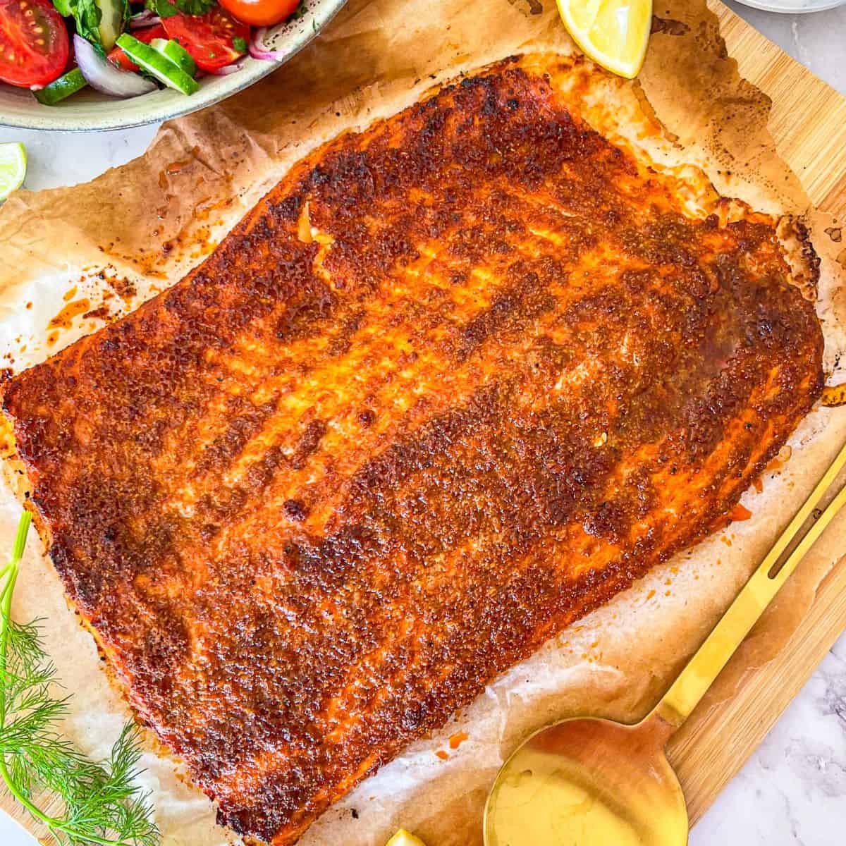 Grand morceau de saumon, brun doré et recouvert d'épices.