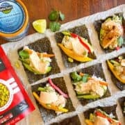 Rouleau à main de sushi posé sur la table à côté de la boîte de thon et d'edamame