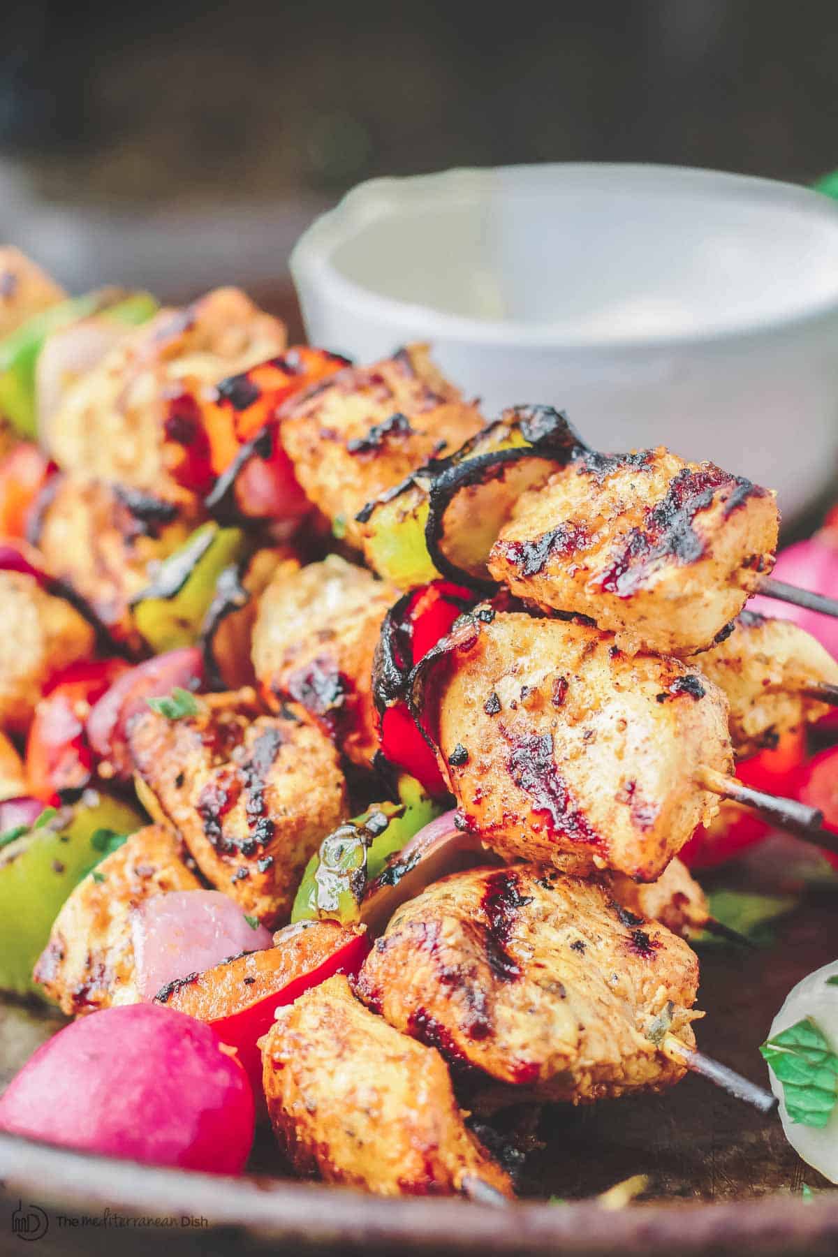 Kabob de poulet grillé empilé les uns sur les autres sur un plat de service