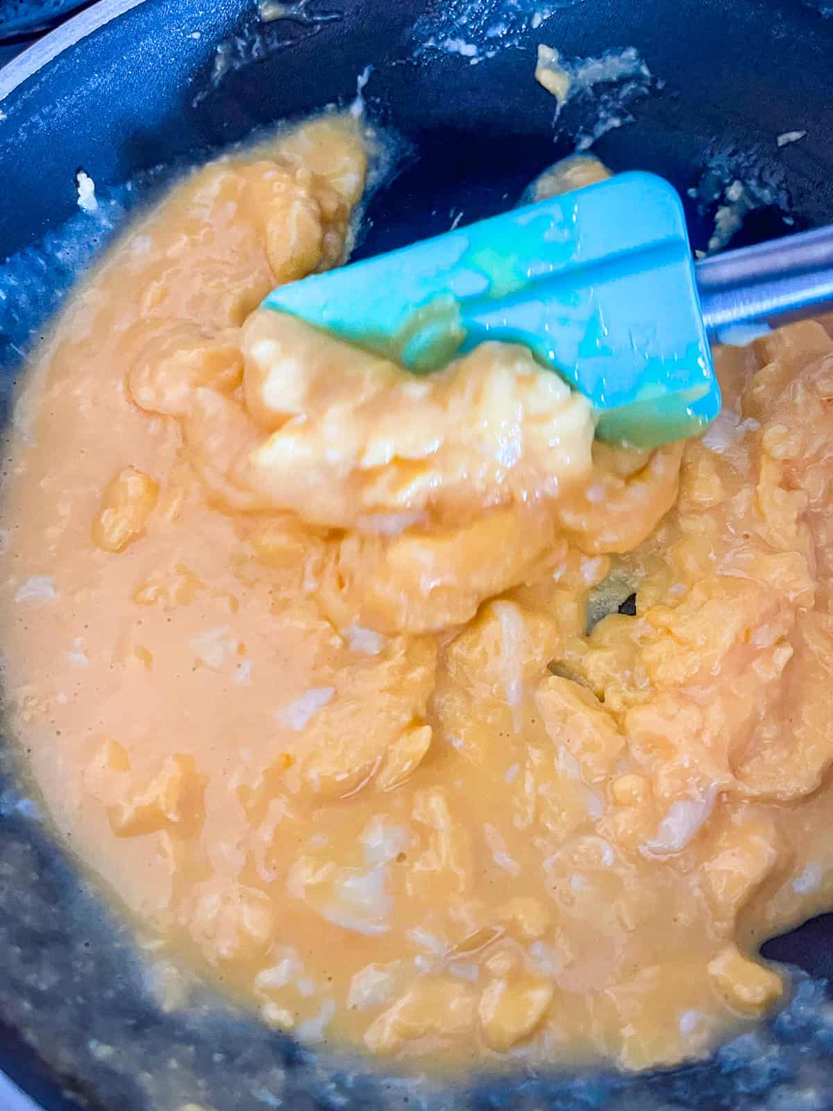 Oeufs brouillés crémeux dans la poêle.