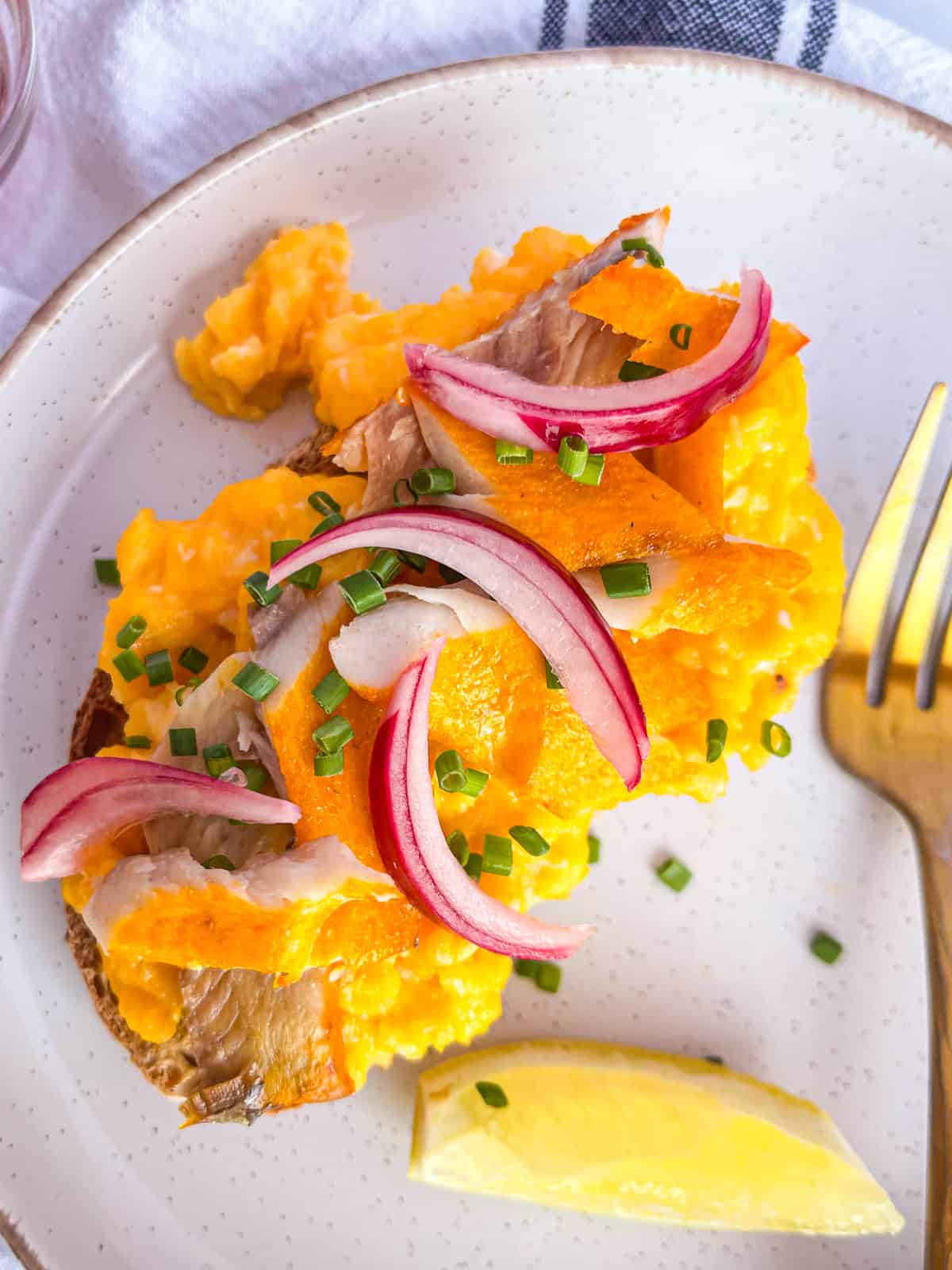 Kippers sur des œufs brouillés et toast garni d'oignons marinés.