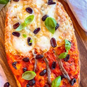 Anchovy Pizza on a board .