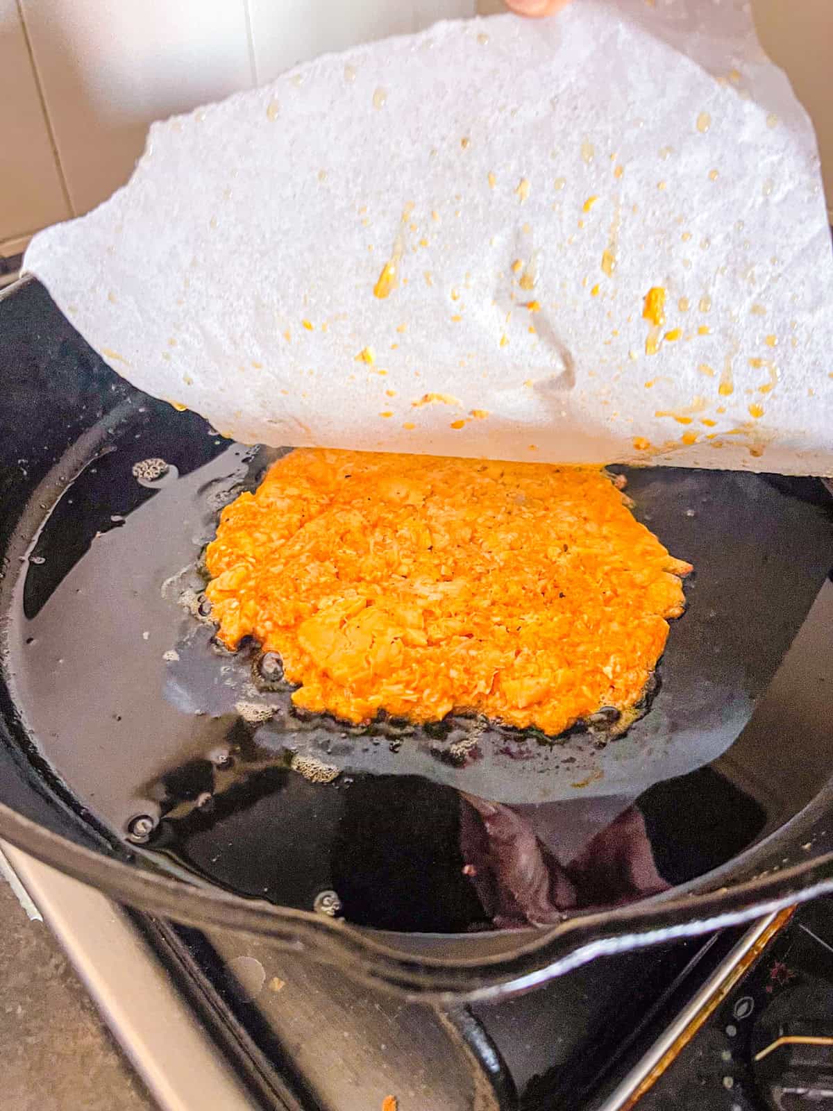 Burger a brisé dans une poêle sous papier parchemin.
