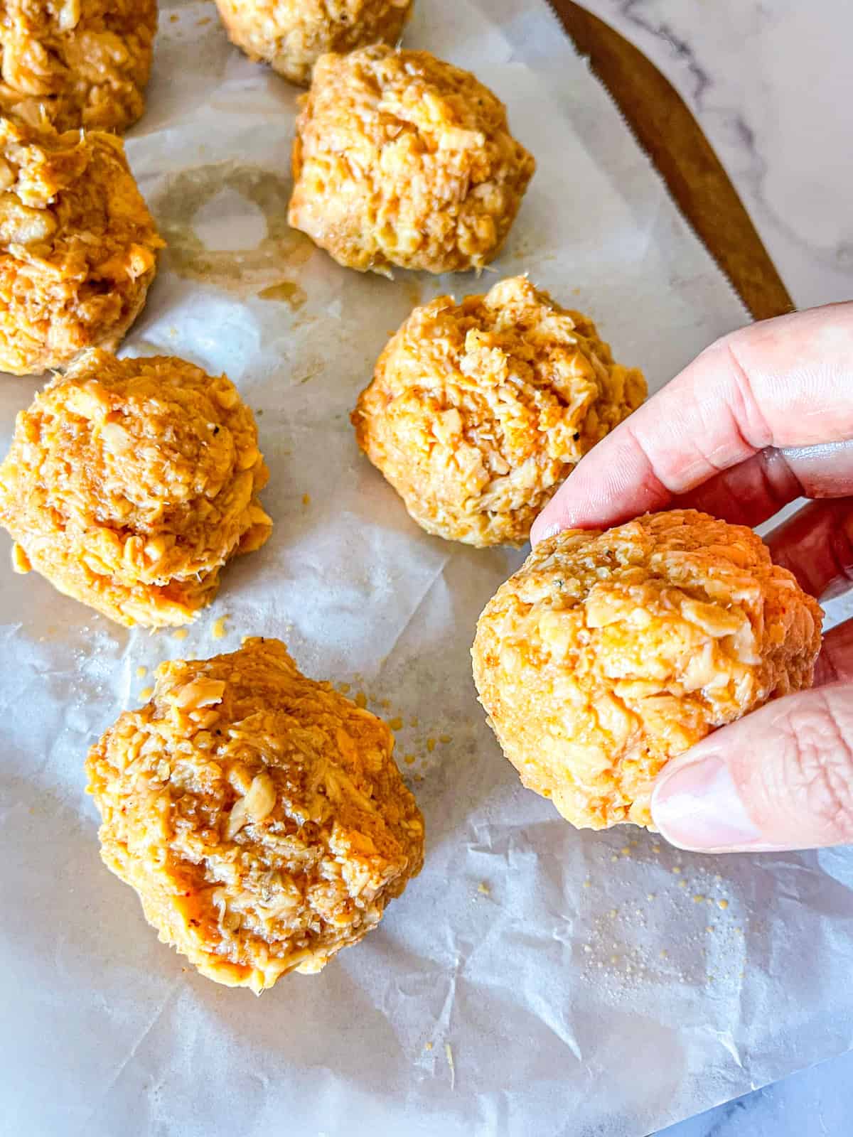 Mélange de saumon en boules sur une feuille de papier parchemin.