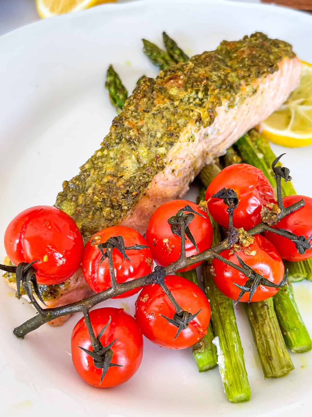Pesto Saumon sur une assiette avec des tomates cerises et des asperges.