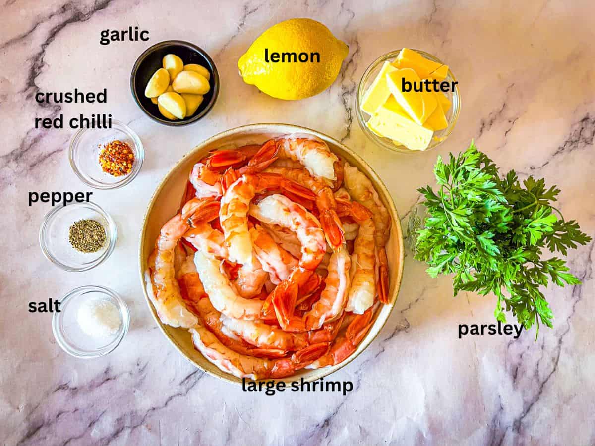 Ingrédients pour les scampi de crevettes sans recette de vin disposés sur une table et étiquetés.