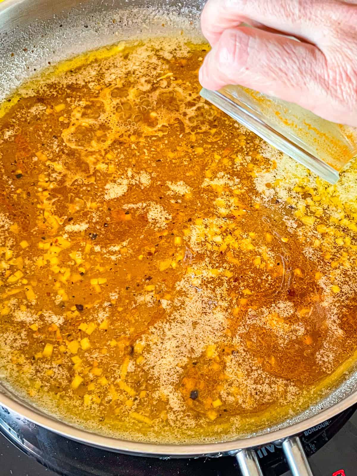 Le stock de crevettes ajouté à la poêle.