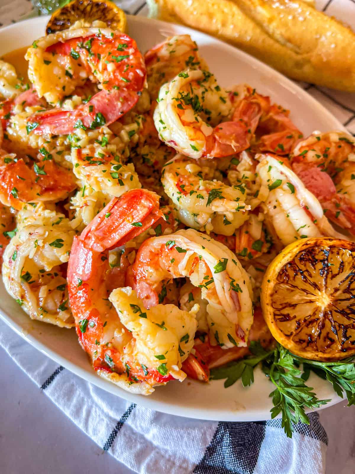 Crevettes jumbo dans une sauce au beurre à l'ail sur une assiette. 