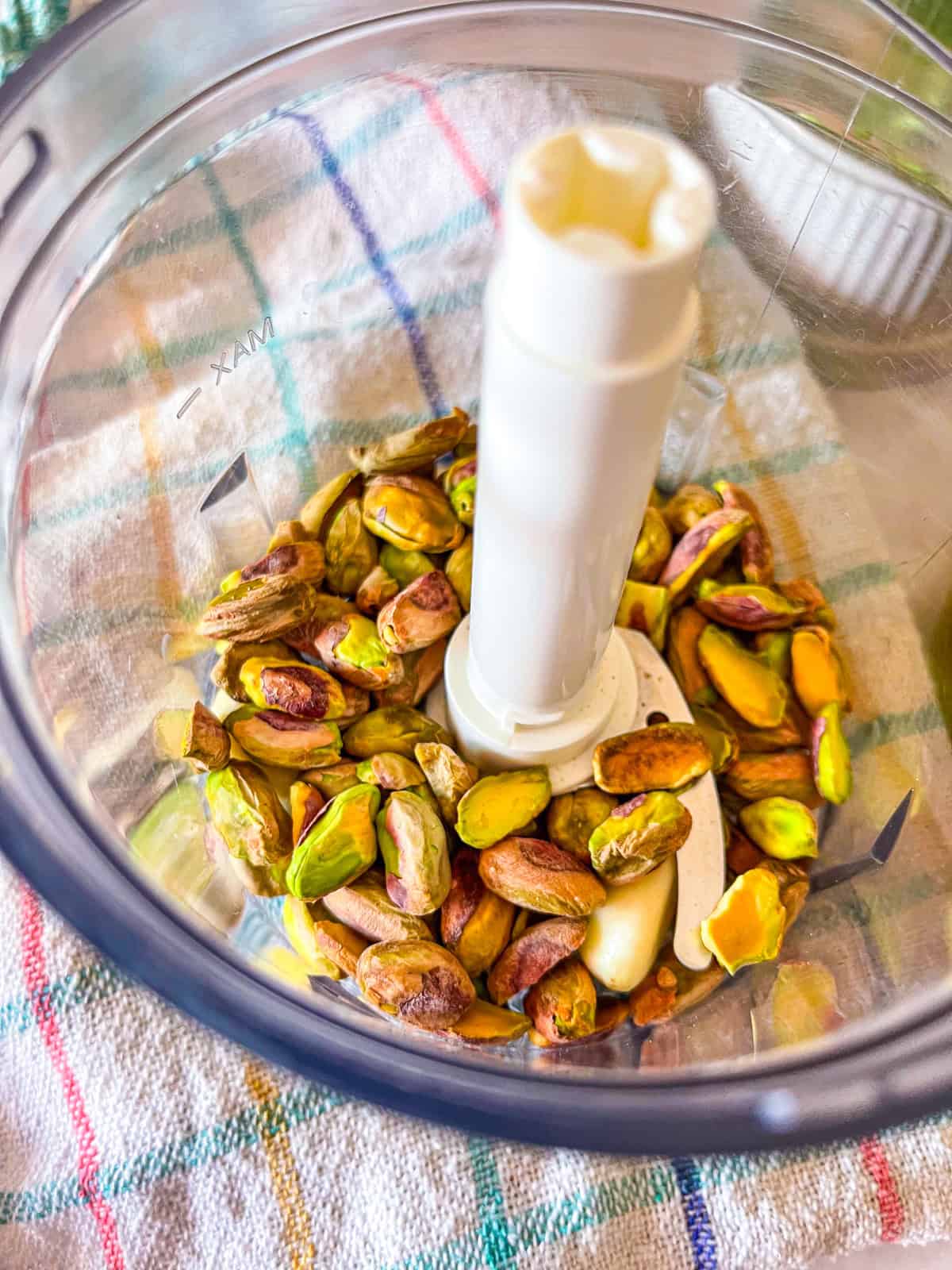 Pistache et gousses d'ail dans un petit robot culinaire. 