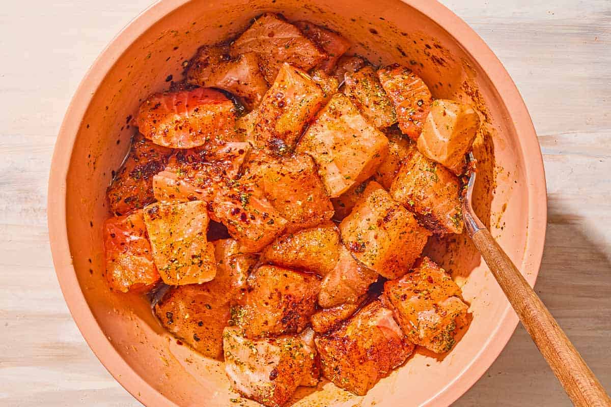 Des piqûres de saumon assaisonnées non cuites dans un bol avec une fourchette.