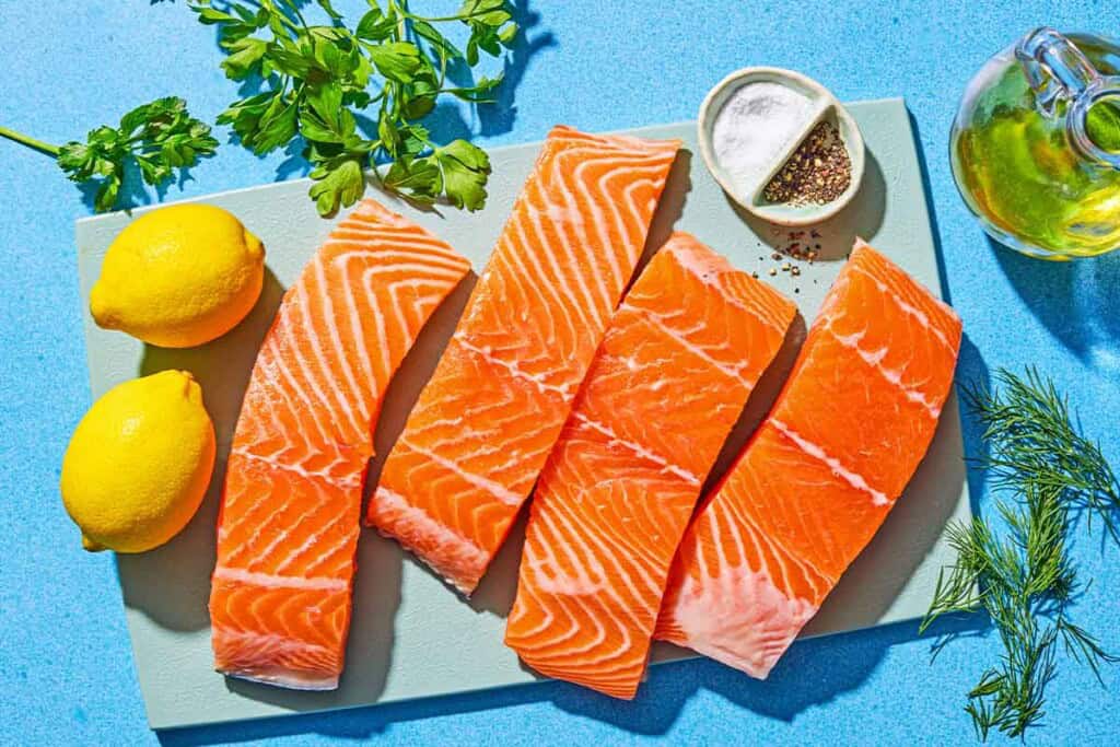 Ingrédients pour saumon au poivre de citron, y compris les filets de saumon, l'huile d'olive, les citrons, l'huile d'olive, l'aneth, le persil, le sel et le poivre.