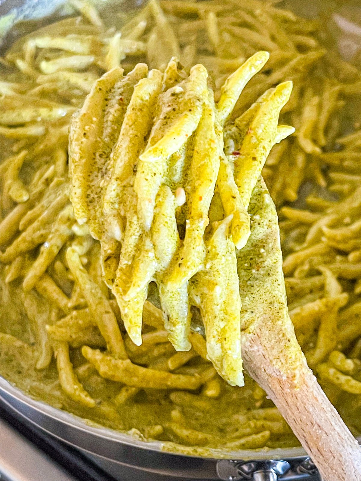 Pâtes cuites dans une poêle avec une cuillère.