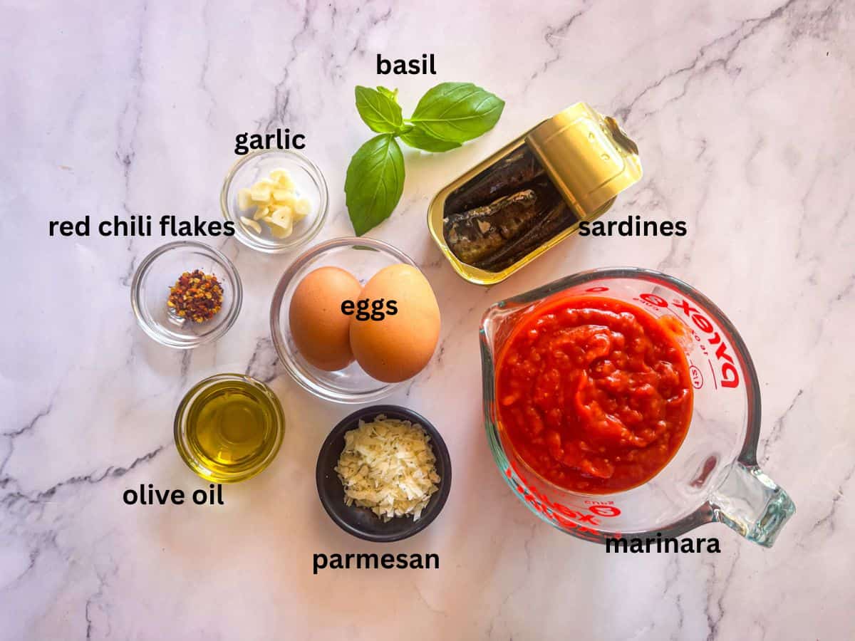 Ingrédients pour les œufs de sardine au purgatoire sur une table.