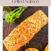 saumon grillé mariné sur une planche de cèdre aux côtés d'un demi citron grillé.