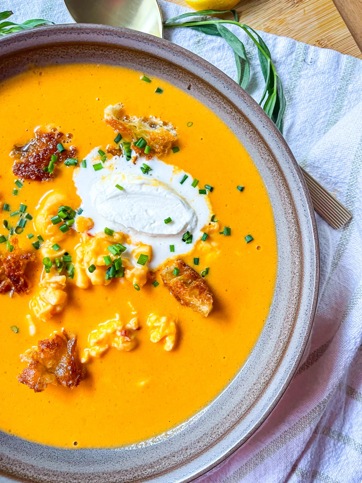 Verser dans des bols et garnir de crème légèrement fouettée, de croûtons au beurre et de ciboulette fraîche.