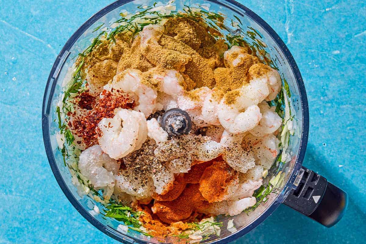 Les ingrédients du kofta aux crevettes dans le bol d'un robot culinaire juste avant d'être mélangés.
