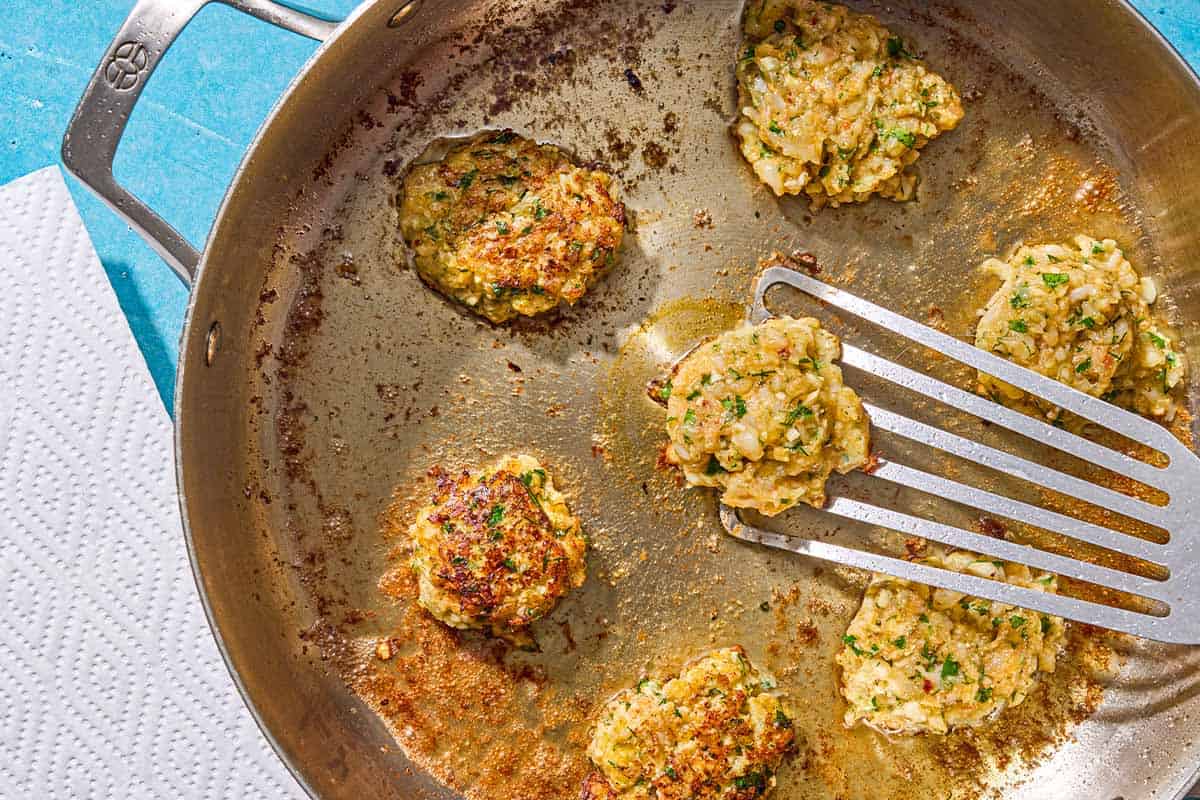 Le kofta aux crevettes est frit dans une poêle. L'un est en train d'être retourné à la spatule.