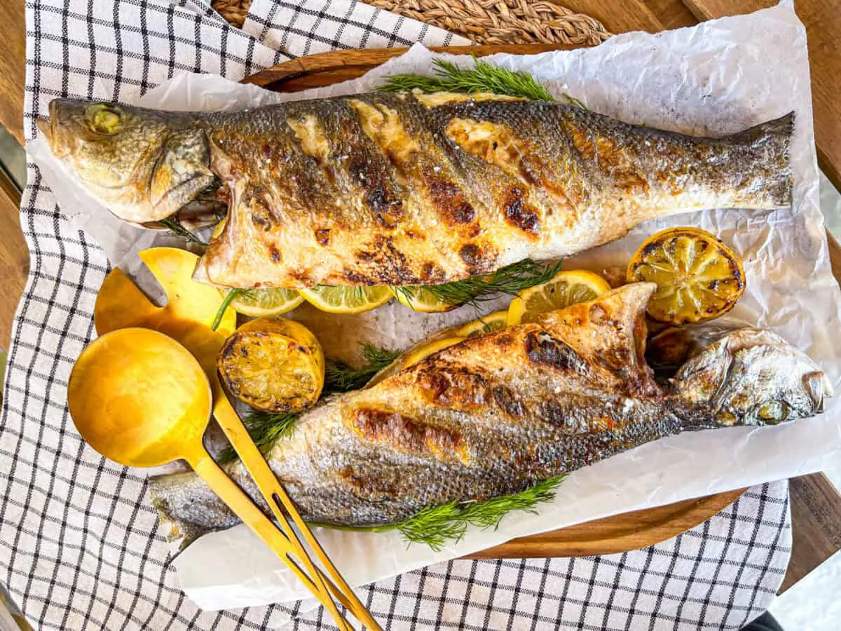 Deux branzinos entiers grillés servis avec du citron