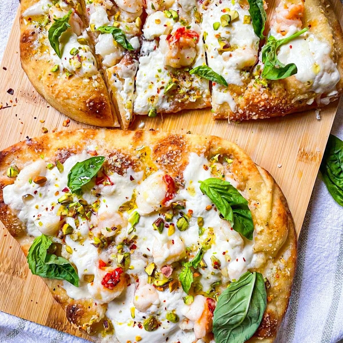 2 Lobster pizzas on a board.