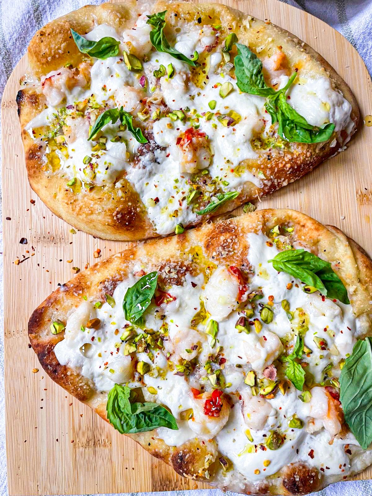 2 Pizzas au homard sur une planche.