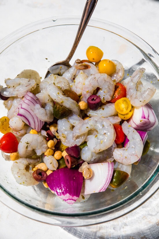 Crevettes, tomates, olives, oignons dans un bol