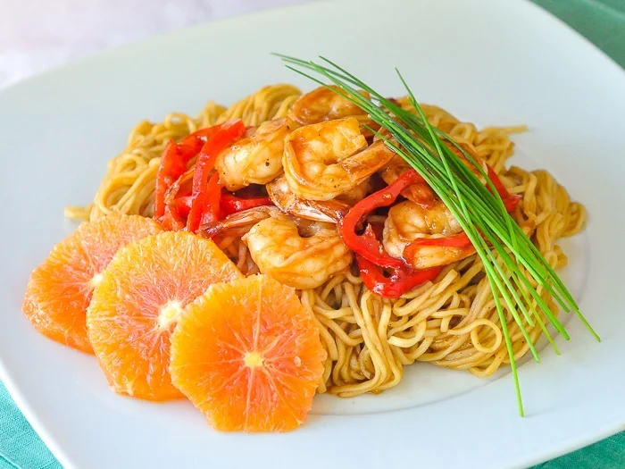Photo large de 15 minutes de crevettes et de nouilles Hoisin à l'orange d'une portion individuelle sur une assiette blanche